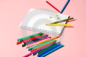 Colorful felt tip pens with blank notepad paper on pink pastel background