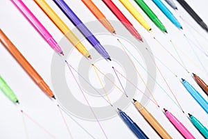 Colorful felt-tip pens on white background with connected drawn lines, connection and communication concept.