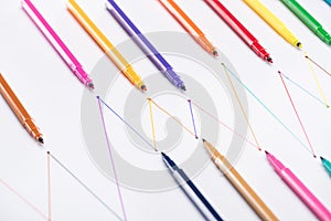 Colorful felt-tip pens on white background with connected drawn lines, connection and communication concept.