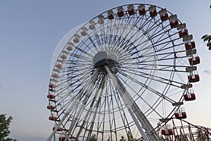 Colorful Ferris wheel of the amusement park in the blue sky and cloud background