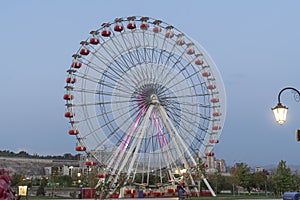 Colorful Ferris wheel of the amusement park in the blue sky and cloud background