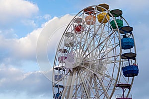 Colorful ferris wheel with a background of blue sky and clouds in the afternoon. Tibidabo, Barcelona