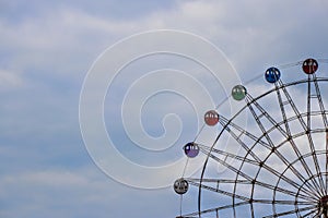 Colorful ferris wheel on blue sky background.