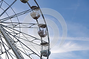 Colorful Ferris wheel in the park on a blue sky background