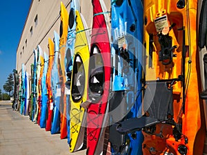 Colorful fiberglass kayaks on display outside sporting goods store