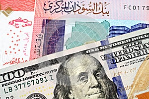 A colorful fifty Sudanese pound bank note with an American one hundred dollar bill