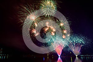 Colorful fireworks against a black night sky.Fireworks for new year. Beautiful colorful fireworks display on the urban lake for