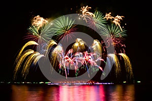 Colorful fireworks celebration and the night sky with reflection on the water