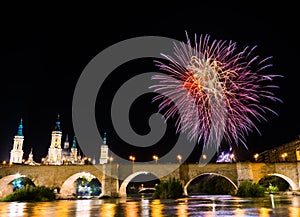 colorful fireworks exploding in the dark night sky creating light and color effects above the bridge and close to Basilica of