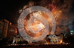 Colorful fireworks exploding over historic buildings and crowd