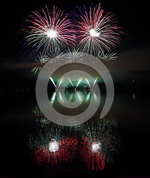 Colorful fireworks with reflection on lake.