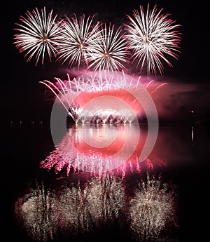 Colorful fireworks with reflection on lake.