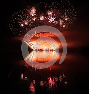 Colorful fireworks with reflection on lake.