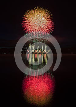 Colorful fireworks with reflection on lake.