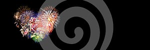 Colorful fireworks in the shape of a heart on panoramic black background. Valentine`s day banner