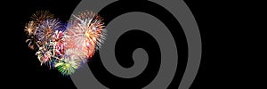 Colorful fireworks in the shape of a heart on panoramic black background. Valentine`s day banner photo