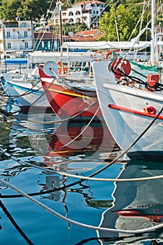 Colorful fishing boats and their reflections in a water of Skiathos harbor, island of Skiathos