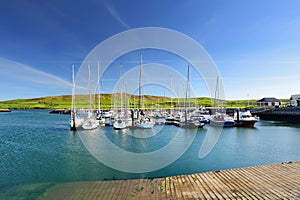 Colorful fishing boats and yachts at the harbor of Dingle town on the West Atlantic coast of Ireland. Small towns and villages on