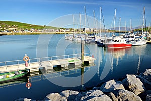 Colorful fishing boats and yachts at the harbor of Dingle town on the West Atlantic coast of Ireland. Small towns and villages on