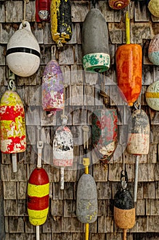 Colorful Fishing Buoys Hanging on Wood Shingle Wall