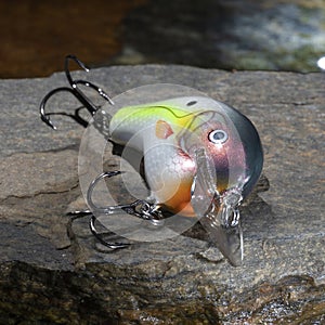 Colorful fishing lure next to a lake's water