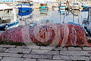 Colorful fishing net laying on a pier, closeup photo with selective focus.