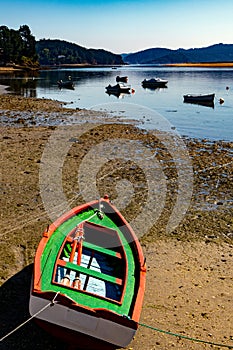 Colorful fishing row boat ashore with low tide.