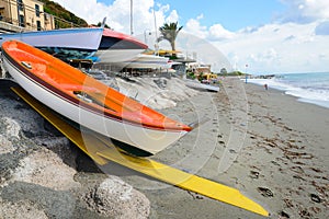 Colorful fishing wooden boat moored on the beach - coral color