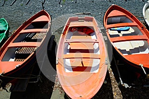 Colorful fishing wooden boat moored on the beach - coral color