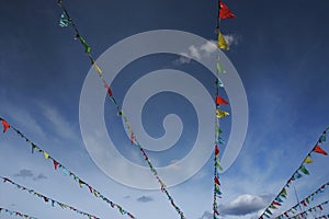 Colorful flags bunting against blue sky.