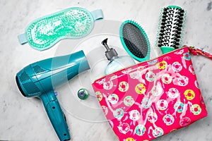 Colorful flat lay of women`s styling products in a cosmetic bag