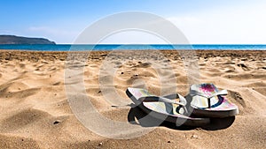 Colorful flip flop sandals on the sandy beach