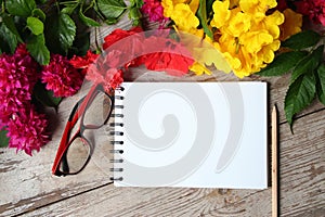 Colorful florals wite notebook placed on the table old wooden