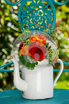 Colorful flower bouquet with dalias in a enamel milk jug photo