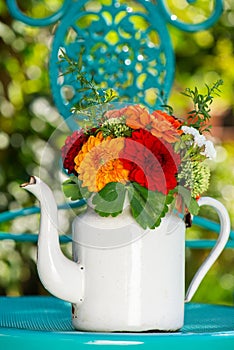 Colorful flower bouquet with dalias in a enamel milk jug photo