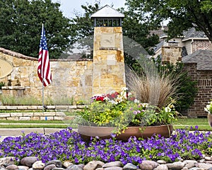 Colorful flower garden and American Flag at entrance to neighborhood in Frisco, Texas.