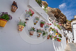 Colorful flower pots and rock overhangs - Setenil de las Bodegas, Andalusia, Spain