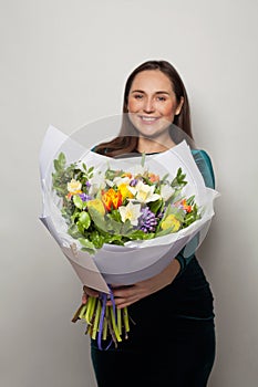 Colorful flowers bouquet in beautiful woman hands on white background