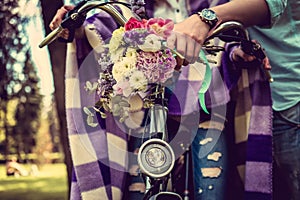 Colorful flowers bouquet on bicycle handlebar.