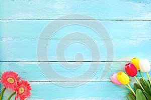 Colorful flowers bouquet on blue wooden background.