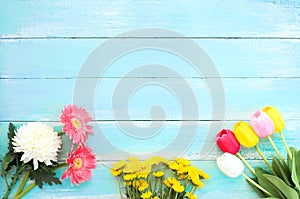 Colorful flowers bouquet on blue wooden background.