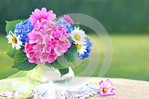 Colorful flowers bouquet in glass vase isolated on blur background.