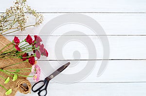 Colorful flowers bouquet on white wooden background.