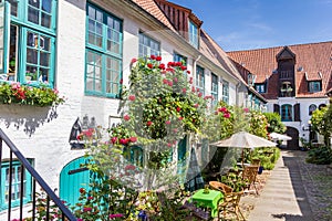 Colorful flowers at the facade of a white house in Flensburg