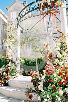 Colorful flowers on the steps and columns of a wedding rotunda in the garden