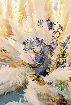 Colorful flowers surrounded by a cortaderia in a wedding arch