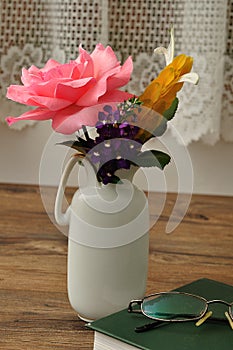 Colorful flowers in a vase with a hardcover storybook