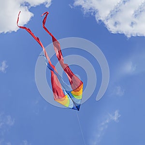 Colorful flying kite flying in sky with clouds