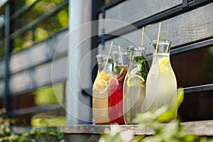 Colorful fresh lemonades in glass bottles.