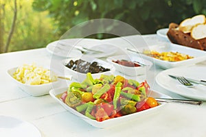 Colorful fresh organic vegetable salad on white table. Peppers, tomato cheese